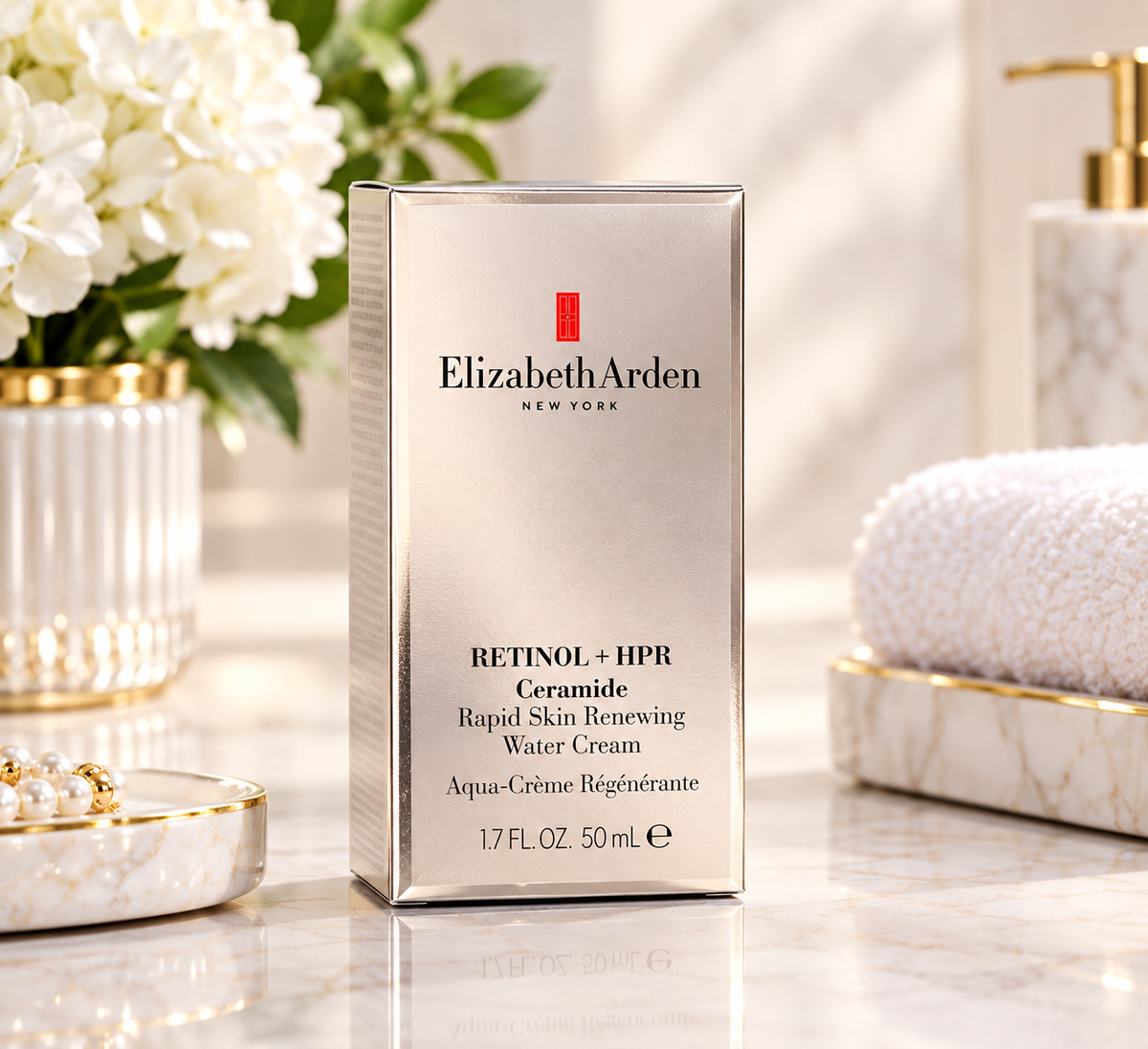 Elizabeth Arden Retinol + HPR Ceramide Rapid Skin Renewing Water Cream 50 mL box standing on a marble surface, styled with white flowers, a folded towel, and gold-accented bathroom props in soft natural light.