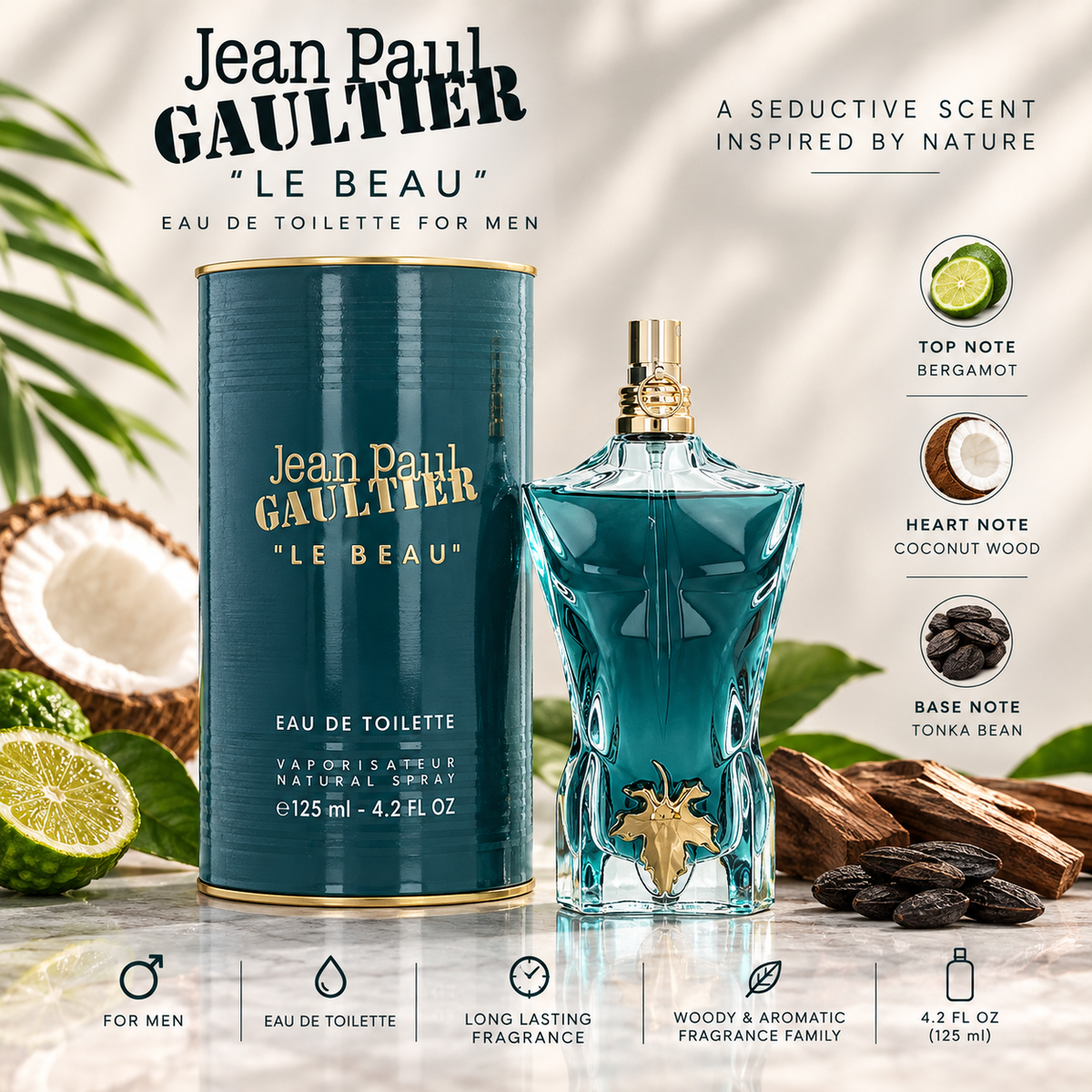 Jean Paul Gaultier Le Beau Eau de Toilette bottle and its cylindrical packaging box, styled with tropical ingredients like a sliced lime, a coconut, and cocoa beans on a light marble background. The bottle is translucent teal-blue with a gold cap and a gold beetle-shaped atomizer, while the box is a matching teal-blue with gold lettering.