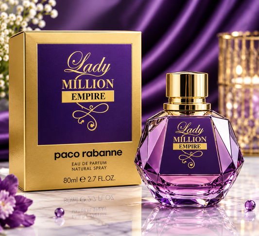 Paco Rabanne Lady Million Empire Eau de Parfum bottle and its gold and purple packaging box, displayed on a reflective surface with purple satin fabric and decorative flowers in the background.